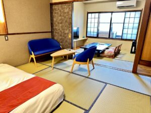 Tatami room with chairs, low table, and bed