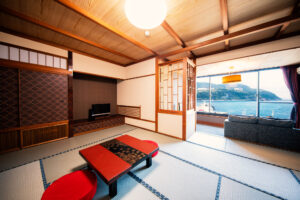 Tatami room with low table, sofa, and ocean window