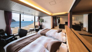 Twin beds in guest room facing ocean windows