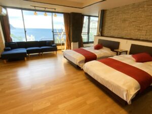 Twin beds in guest room with ocean-facing windows