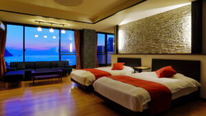 Twin beds in guest room with ocean view seating area