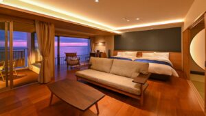 Chambre avec lits jumeaux, canapé et fenêtre avec vue sur l’océan