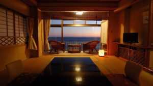 Vue sur le coucher de soleil sur l’océan depuis une chambre d’hôtes en tatami