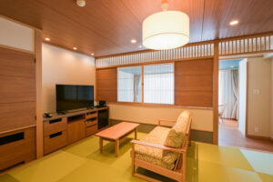 Chambre de style tatami avec canapé, table et télévision