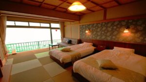Lits jumeaux dans une chambre d’hôtes en tatami près de la fenêtre