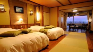 Lits jumeaux dans une chambre d’hôtes en tatami avec sièges sur le balcon