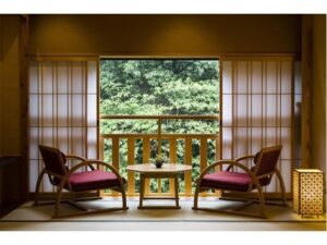 Dos sillas y una mesa junto al balcón con ventana shoji