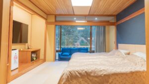 Lits dans une chambre en tatami avec coin salon près de la fenêtre