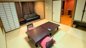 Chambre en tatami avec table basse, chaises de sol et canapé