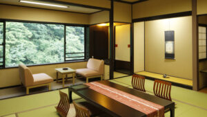 창가 옆 낮은 탁자와 의자가 있는 다다미 객실