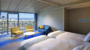 くつろぎスペースとオーシャンビューのあるツインベッドルーム