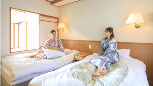 浴衣姿でツインベッドに座る2人の女性