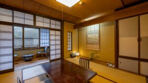 Camera in tatami con tavolo basso e zona salotto adiacente