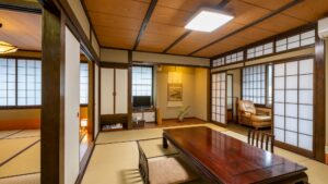 Camera tradizionale in tatami con tavolo basso e zona salotto