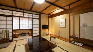 Camera tradizionale con tatami, tavolino basso e area salotto