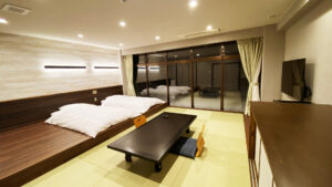 Niedriges Bett neben dem Tatami-Sitzbereich im Gästezimmer