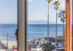 Meerblick durch ein Fenster mit Palmen