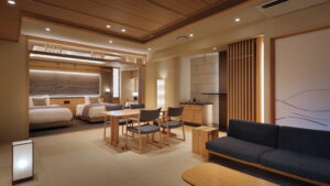 Camera di ryokan con divano, tavolo, sedie e letti singoli