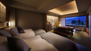 Letti singoli in una camera di ryokan con seduta accanto alla finestra