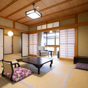 Chambre en tatami avec table basse, chaises de sol et fauteuil