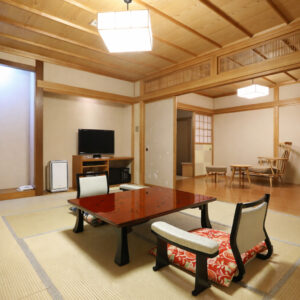 Chambre en tatami avec table basse, chaises de sol et coin salon
