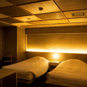 柔和灯光下客房内的双床