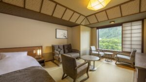 Tatami room with bed, chairs, sofa, and window view