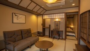 Tatami room with sofa, round table, and adjoining bedroom