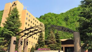 带有入口拱门和周围树木的酒店外观