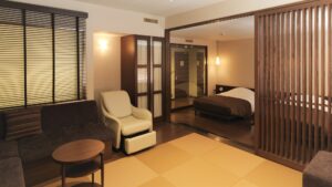 榻榻米休息区配有沙发和椅子，后方是床铺