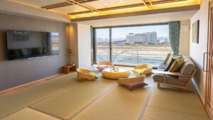 Chambre en tatami avec table basse, chaises de sol et canapé