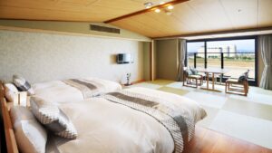 Lits jumeaux dans une chambre d’hôtes en tatami près de la fenêtre