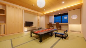 Habitación de tatami con mesa baja y sillas junto a la ventana