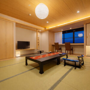 Habitación de tatami con mesa baja y asientos junto a la ventana