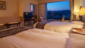 Camas individuales en una habitación con vista por la ventana