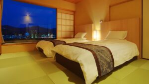 Dos camas individuales en una habitación de tatami junto a una gran ventana