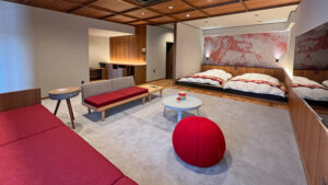 Habitación con camas bajas, sofá y mesa redonda
