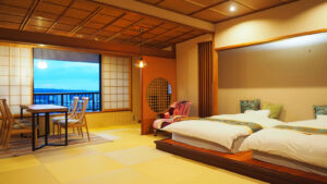 Habitación de tatami con dos camas y asientos junto a la ventana