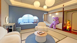 Habitación de tatami con sillas, mesa y un gran oso de peluche