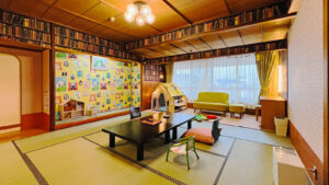Habitación de tatami con mesa baja, cojines, sofá y tienda de juego