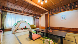 Habitación de tatami con mesa baja, sillas de suelo y tienda de juego