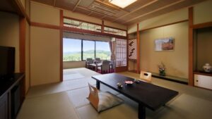 窓際にローテーブルと椅子がある畳の客室