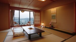 窓辺に低いテーブルと椅子がある畳の部屋