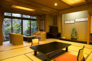 Tatami room with low table, chairs, and window view