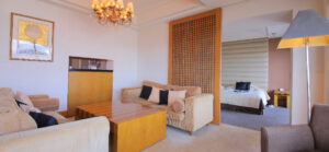 Guest room sitting area with sofas and bed beyond
