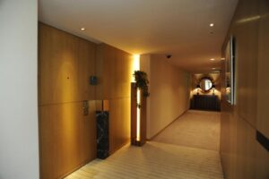 Hotel hallway with wood-paneled walls and mirror.