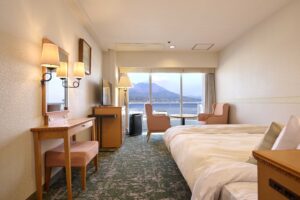 Twin beds in room with desk and ocean view