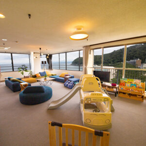 ソファやおもちゃ、大きな窓のある屋内プレイルーム