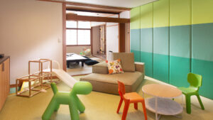 ソファ、テーブル、子ども用椅子のある客室のシーティングエリア