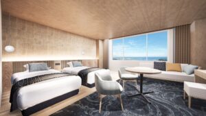 Lits jumeaux dans une chambre avec canapé et vue sur l’océan